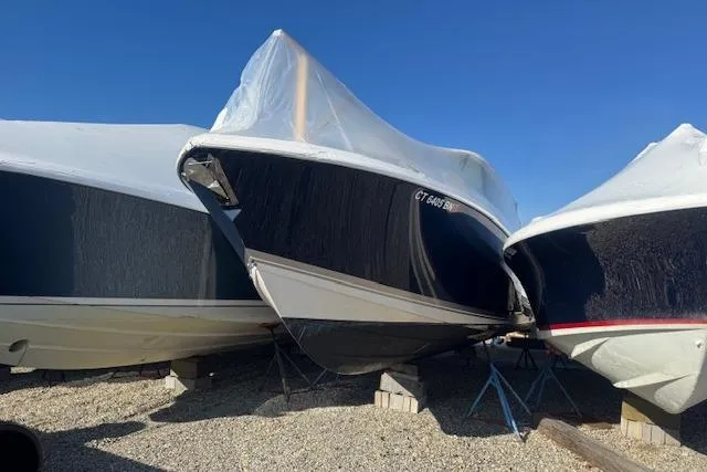 The Image of 2023 Pursuit DC 295 Dual Console boat covered and stored outdoors. - 24