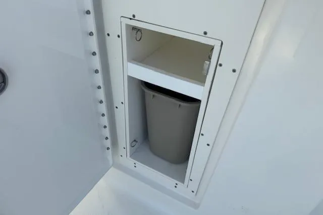 Slide: The Image of Storage compartment with trash bin on 2023 Pursuit DC 295 Dual Console boat. - 27