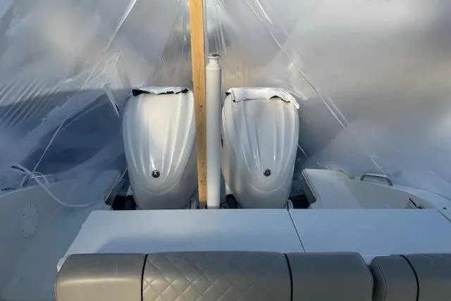 Slide: The Image of 2023 Pursuit DC 295 Dual Console boat engines under protective cover. - 28