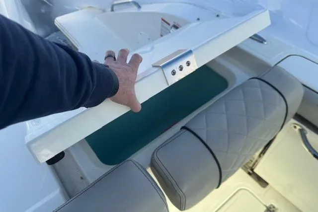 Slide: The Image of 2023 Pursuit DC 295 Dual Console boat interior with storage compartment open. - 30