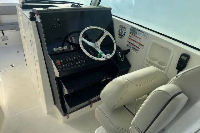Slide: The Image of 2023 Pursuit DC 295 Dual Console boat interior with steering wheel and control panel. - 34