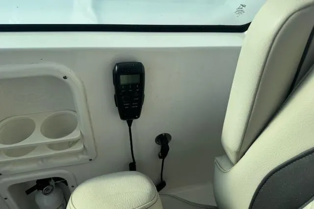 Slide: The Image of 2023 Pursuit DC 295 Dual Console interior with radio and cup holders. - 38