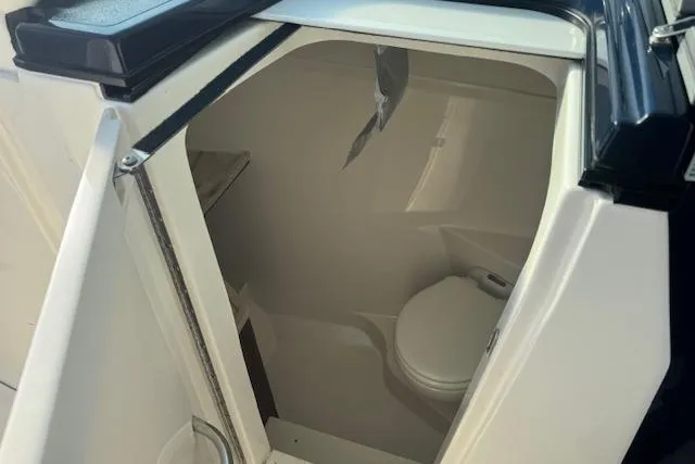 Slide: The Image of 2023 Pursuit DC 295 Dual Console boat interior with compact marine toilet. - 42