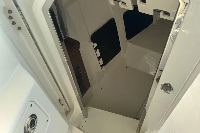 Slide: The Image of 2023 Pursuit DC 295 Dual Console interior cabin view, showcasing storage space. - 44