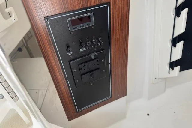 Slide: The Image of 2023 Pursuit DC 295 Dual Console control panel with wood finish and switches. - 45