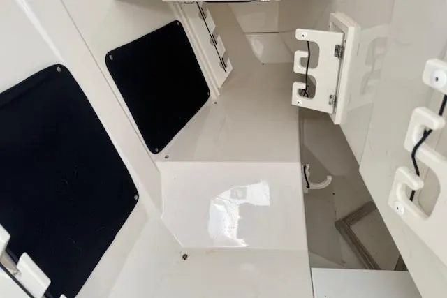 Slide: The Image of 2023 Pursuit DC 295 Dual Console interior, featuring sleek white surfaces and storage compartments. - 46