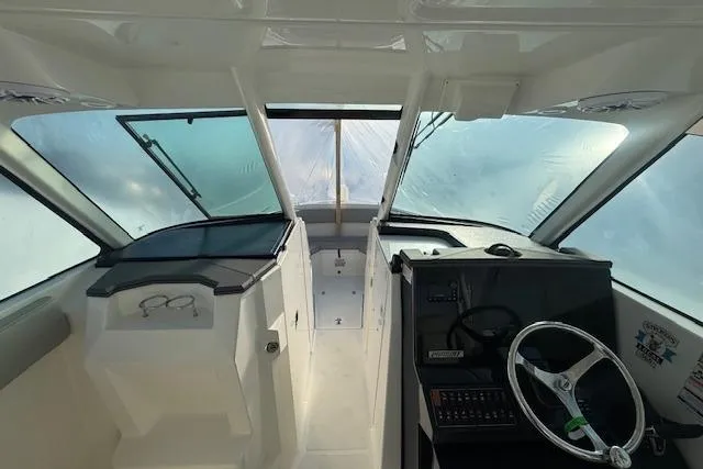 Slide: The Image of 2023 Pursuit DC 295 Dual Console boat interior with steering wheel and dashboard. - 48