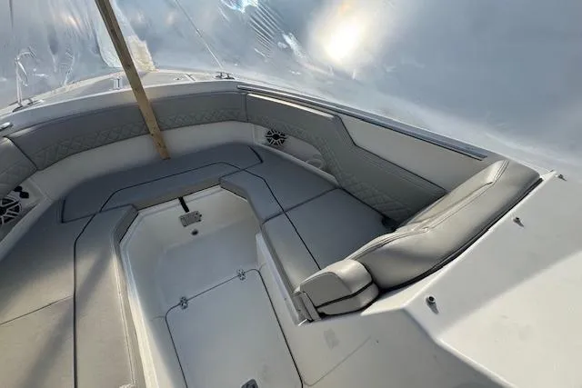 Slide: The Image of 2023 Pursuit DC 295 Dual Console boat interior with cushioned seating and storage compartments. - 51