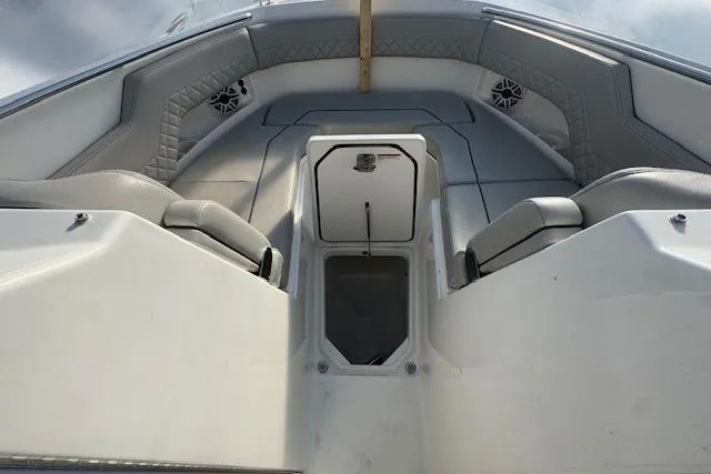 Slide: The Image of 2023 Pursuit DC 295 Dual Console boat interior with cushioned seating and storage compartment. - 53