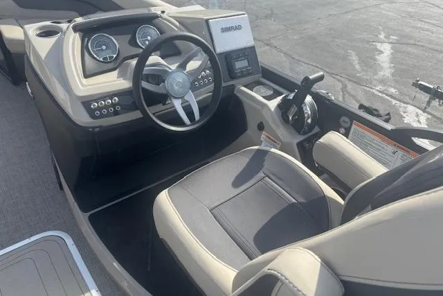 Slide: The Image of 2023 Barletta C22UC boat cockpit with steering wheel, gauges, and Simrad display. - 5
