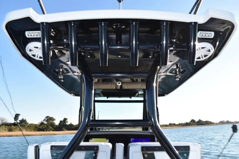 Slide: The Image of 2022 Blackfin 272 CC boat with sleek T-top and rod holders on open water. - 22
