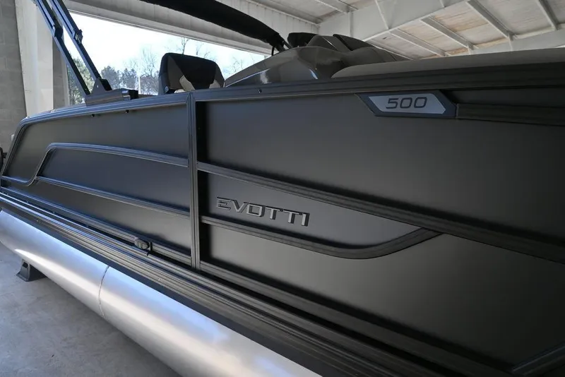 Slide: The Image of 2026 Evotti 521QL boat, sleek black design, side view in a covered area. - 7