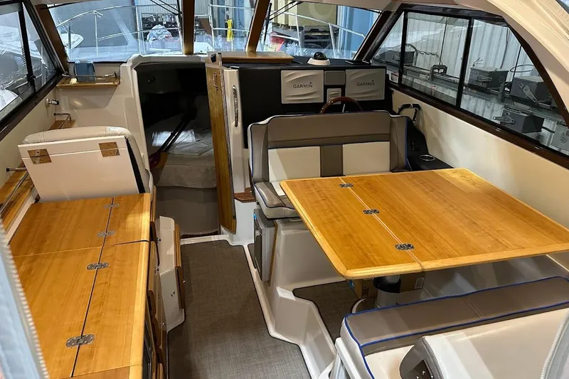 Slide: The Image of 2017 Cutwater C-302 Coupe interior with wood table, seating, and navigation equipment. - 26