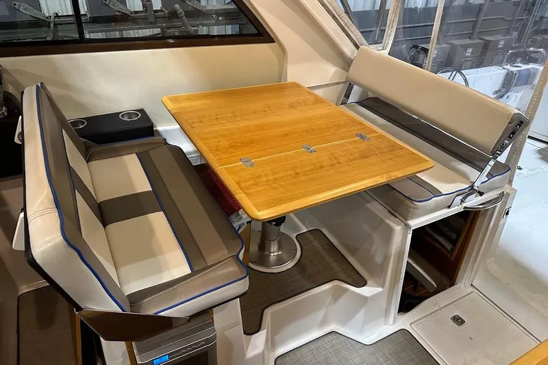 Slide: The Image of 2017 Cutwater C-302 Coupe interior with wooden table and cushioned seating. - 27