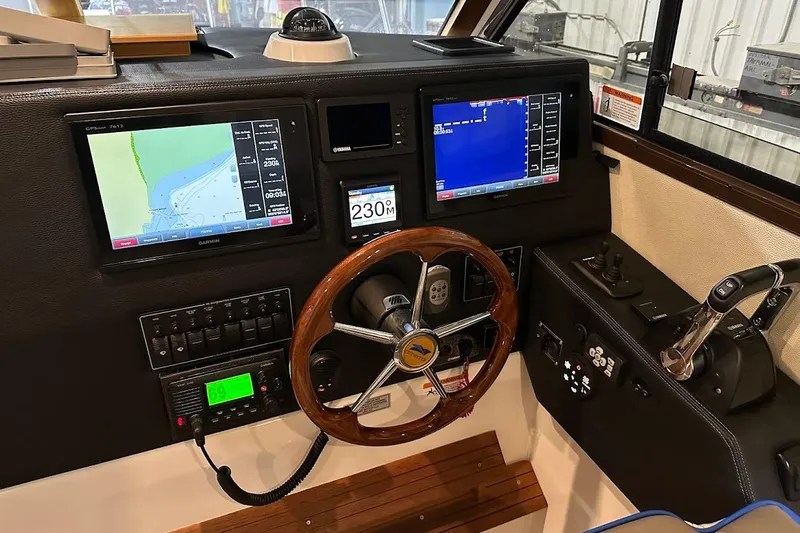 Slide: The Image of 2017 Cutwater C-302 Coupe helm with navigation screens and wooden steering wheel. - 31