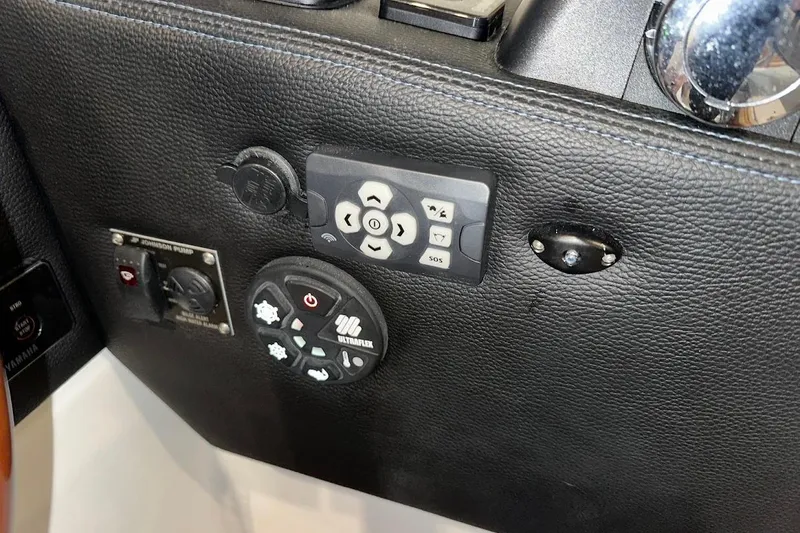 Slide: The Image of Control panel of a 2017 Cutwater C-302 Coupe boat with various switches and buttons. - 35