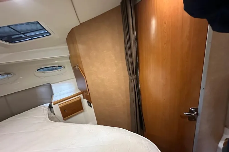 Slide: The Image of 2017 Cutwater C-302 Coupe cabin interior with bed, wooden door, and portholes. - 48