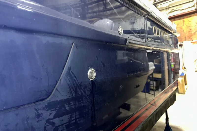 Slide: The Image of 2017 Cutwater C-302 Coupe boat in a workshop, showing side view and detailing. - 6