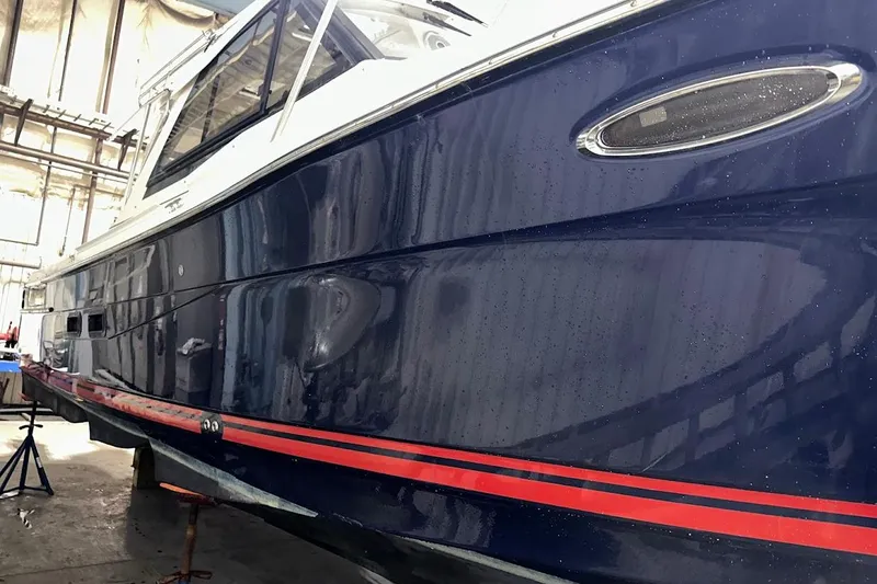 Slide: The Image of 2017 Cutwater C-302 Coupe boat in a workshop, showcasing sleek blue hull design. - 8