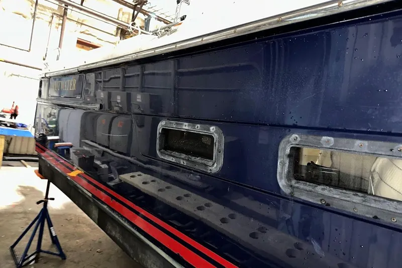 Slide: The Image of 2017 Cutwater C-302 Coupe boat in a workshop, side view with windows. - 9