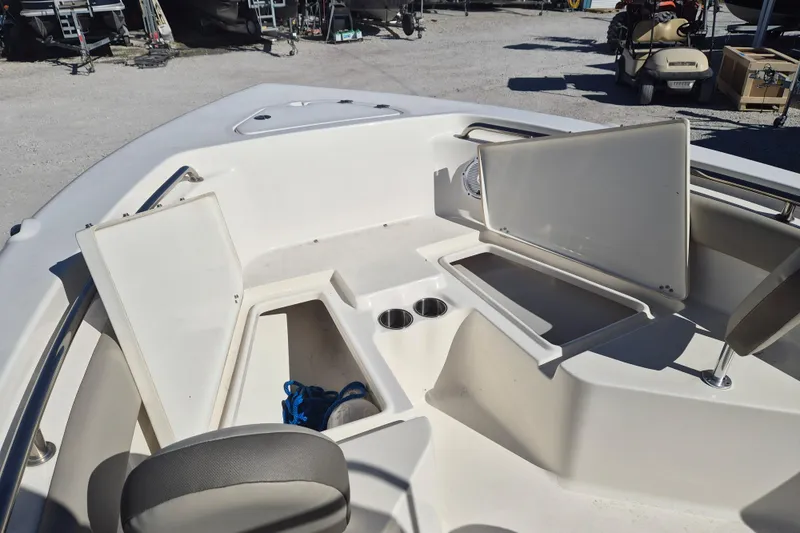 Slide: The Image of 2022 Key West 203 FS boat interior with open storage compartments and cup holders. - 11
