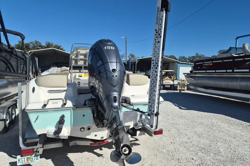Slide: The Image of 2022 Key West 203 FS boat with 150 HP engine, parked in a marina. - 2