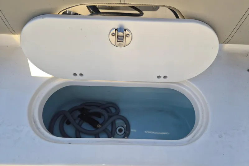 Slide: The Image of 2022 Key West 203 FS boat storage compartment with coiled hose inside. - 5