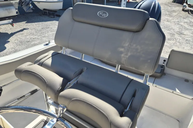 Slide: The Image of 2022 Key West 203 FS boat with gray cushioned seating and steering wheel. - 6