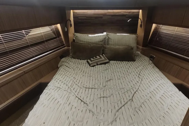 Slide: The Image of Luxurious 2016 Sea Ray L590 yacht bedroom with cozy bedding and elegant wood accents. - 28