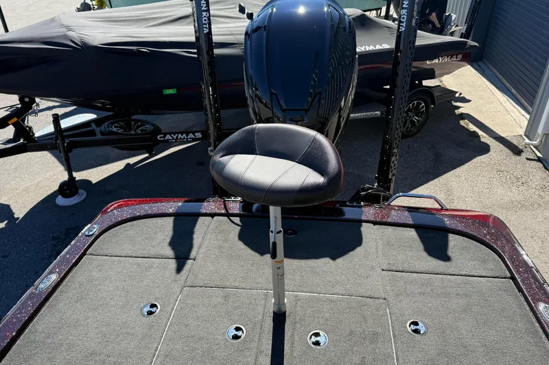 Slide: The Image of 2023 Skeeter ZX200 boat with cushioned seat and motor, parked outdoors. - 8