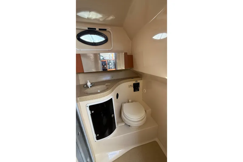 Slide: The Image of 2007 Wellcraft 290 Coastal boat bathroom with sink, toilet, and porthole window. - 14