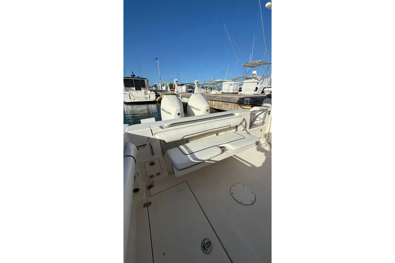 Slide: The Image of 2007 Wellcraft 290 Coastal boat docked, featuring spacious deck and twin Mercury engines. - 9