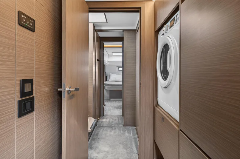Slide: The Image of Modern yacht interior with laundry area, wood paneling, and bedroom view, Leopard 46, 2025 model. - 44