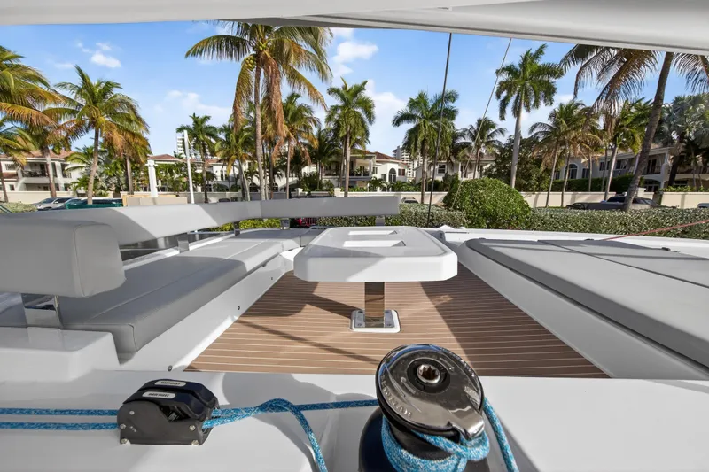 Slide: The Image of Luxurious Leopard 46 yacht deck with seating, table, and palm trees in the background, 2025 model. - 76