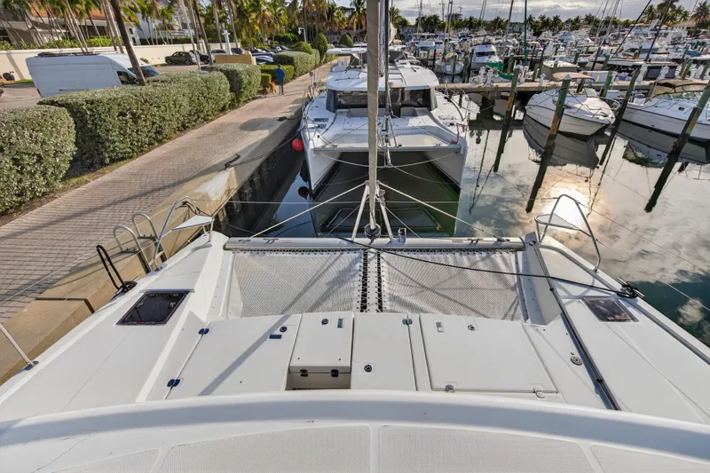 Slide: The Image of 2025 Leopard 46 catamaran docked at marina, surrounded by boats and palm trees. - 82