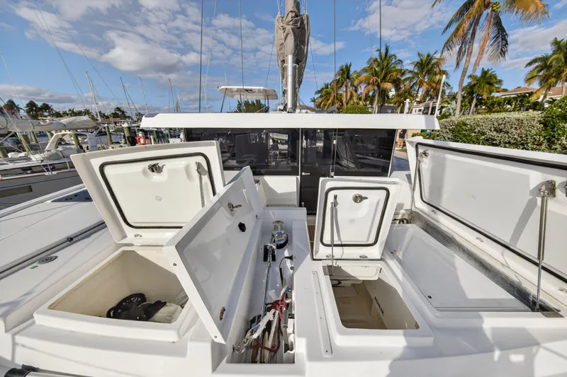 Slide: The Image of 2025 Leopard 46 yacht with open storage compartments, docked near palm trees and other boats. - 89