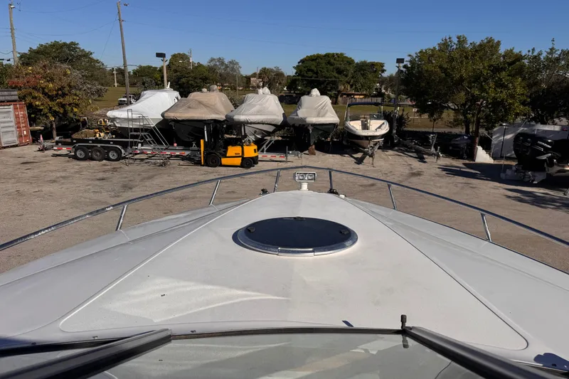 Slide: The Image of Bow view of a 2010 Cobalt 323 boat in a marina with covered vessels. - 19
