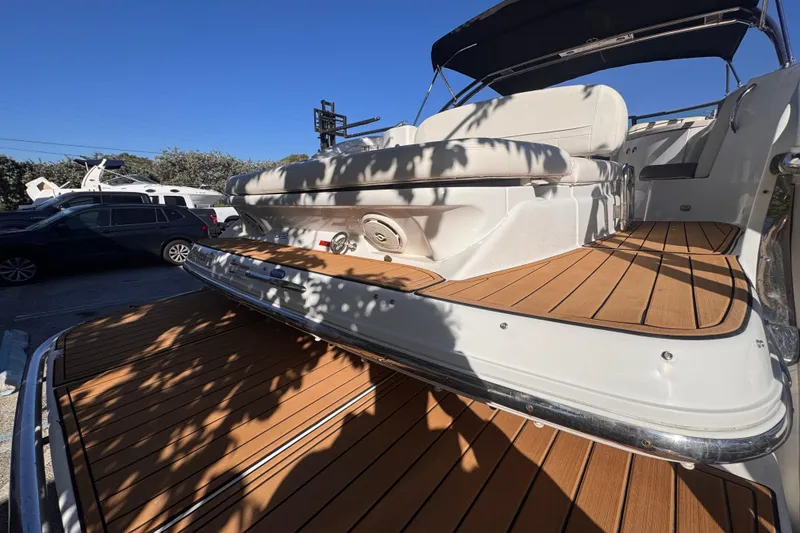 Slide: The Image of 2010 Cobalt 323 boat with teak deck, parked under clear blue sky. - 8