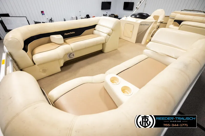 Slide: The Image of 2004 AquaPatio 220 RE boat interior with beige seating and cup holders. - 10