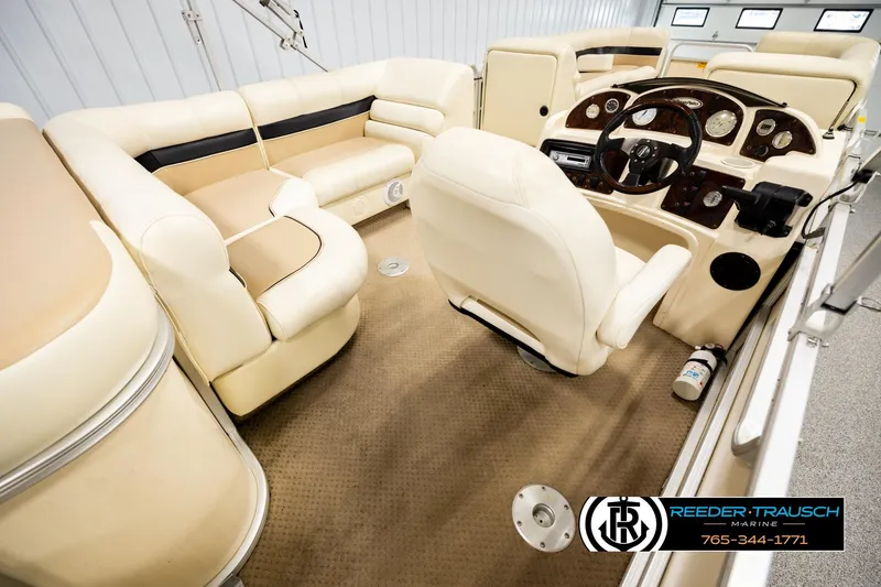 Slide: The Image of Interior of 2004 AquaPatio 220 RE pontoon boat with beige seating and steering console. - 12