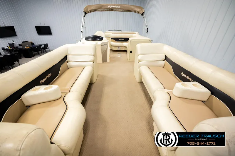 Slide: The Image of 2004 AquaPatio 220 RE pontoon boat interior with beige seating and cup holders. - 13