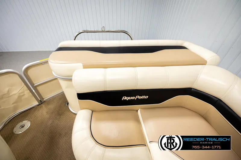 Slide: The Image of 2004 AquaPatio 220 RE boat interior with beige and black seating. - 15