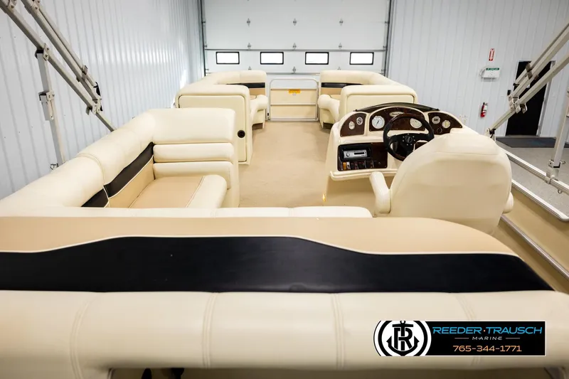 Slide: The Image of Interior of 2004 AquaPatio 220 RE pontoon boat with beige seating and steering console. - 16