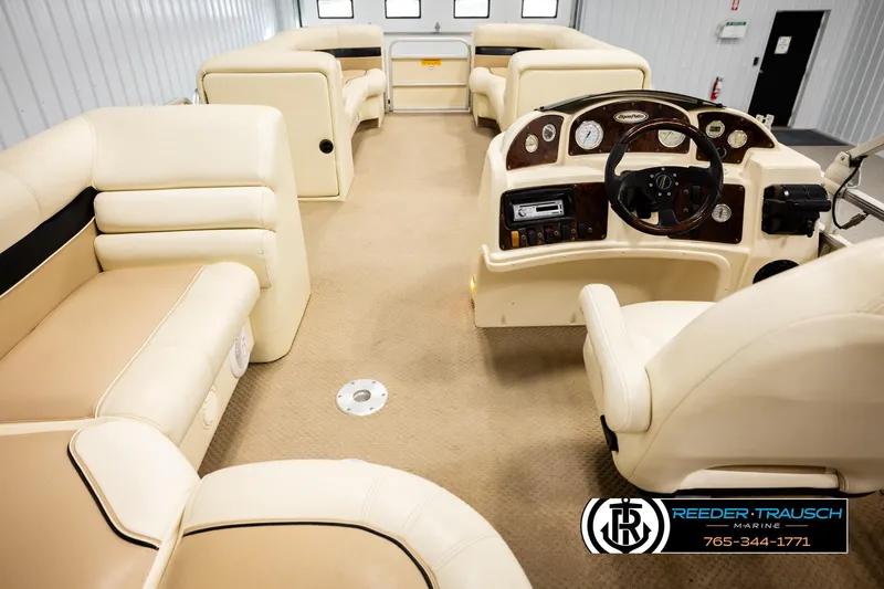 Slide: The Image of 2004 AquaPatio 220 RE boat interior with beige seating and steering console. - 17