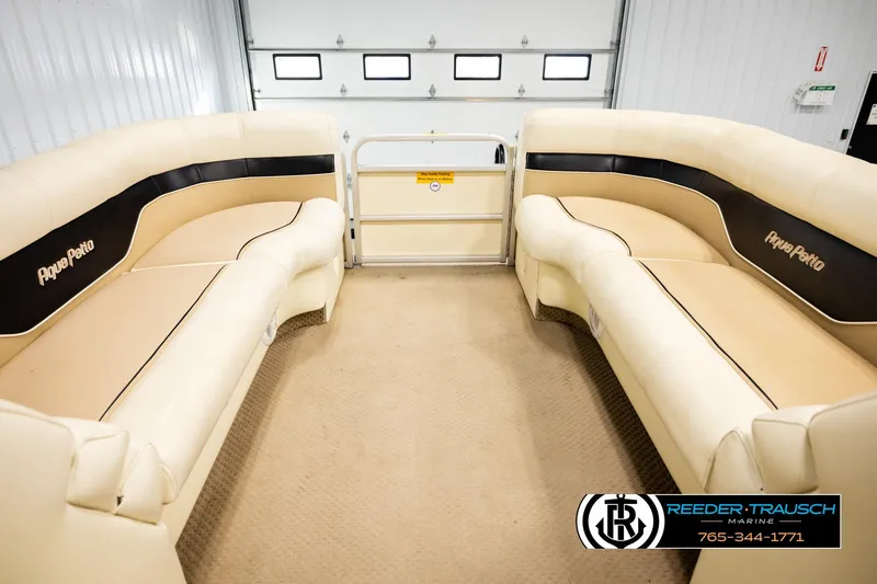 Slide: The Image of Interior of 2004 AquaPatio 220 RE pontoon boat with beige seating and black accents. - 18