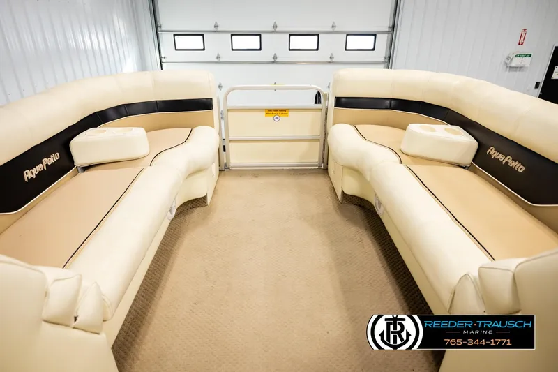 Slide: The Image of 2004 AquaPatio 220 RE pontoon boat interior with beige seating and cup holders. - 19