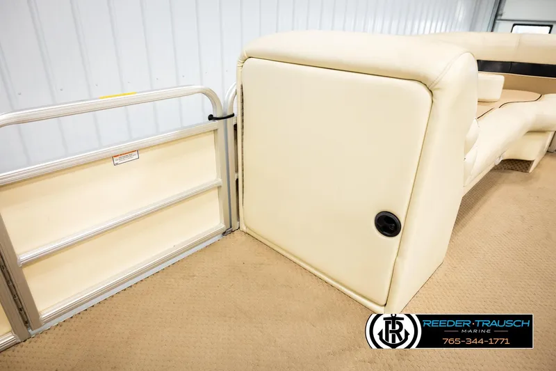 Slide: The Image of 2004 AquaPatio 220 RE boat interior with beige seating and gate, Reeder-Trausch Marine logo. - 20