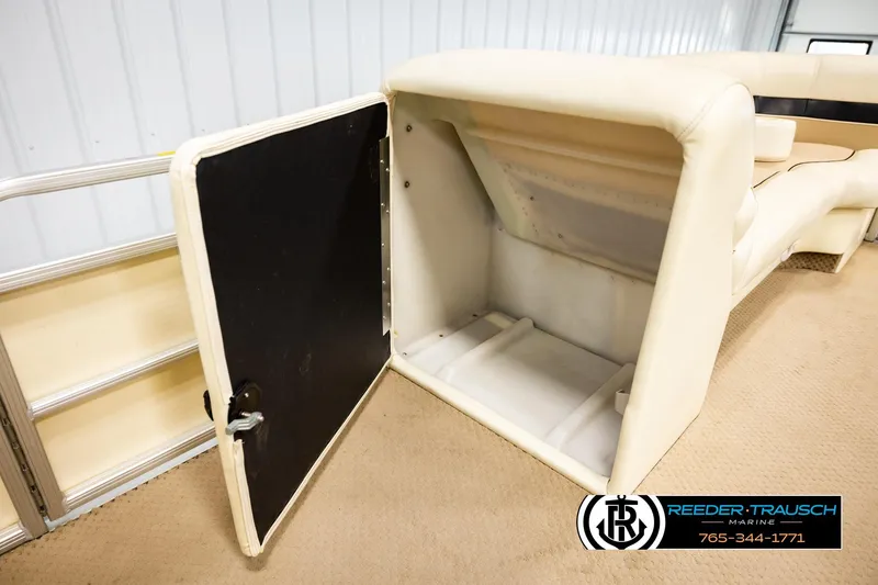 Slide: The Image of 2004 AquaPatio 220 RE boat interior storage compartment with open door, beige seating. - 21