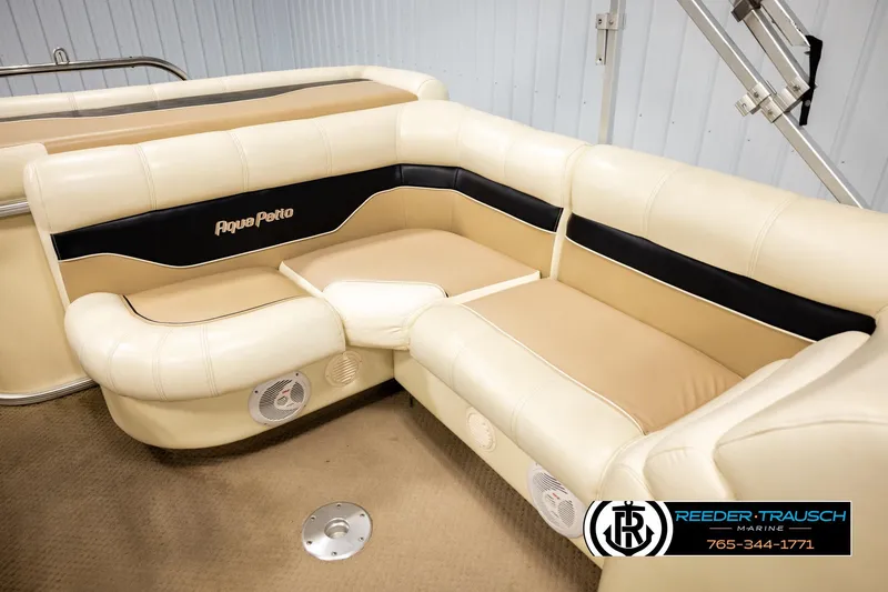 Slide: The Image of 2004 AquaPatio 220 RE boat interior with beige seating and black accents. - 24
