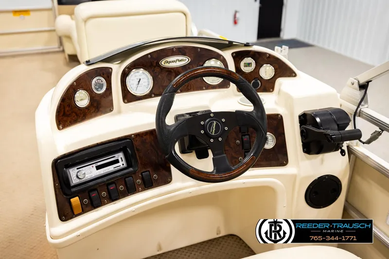 Slide: The Image of 2004 AquaPatio 220 RE boat dashboard with steering wheel and control panel. - 28